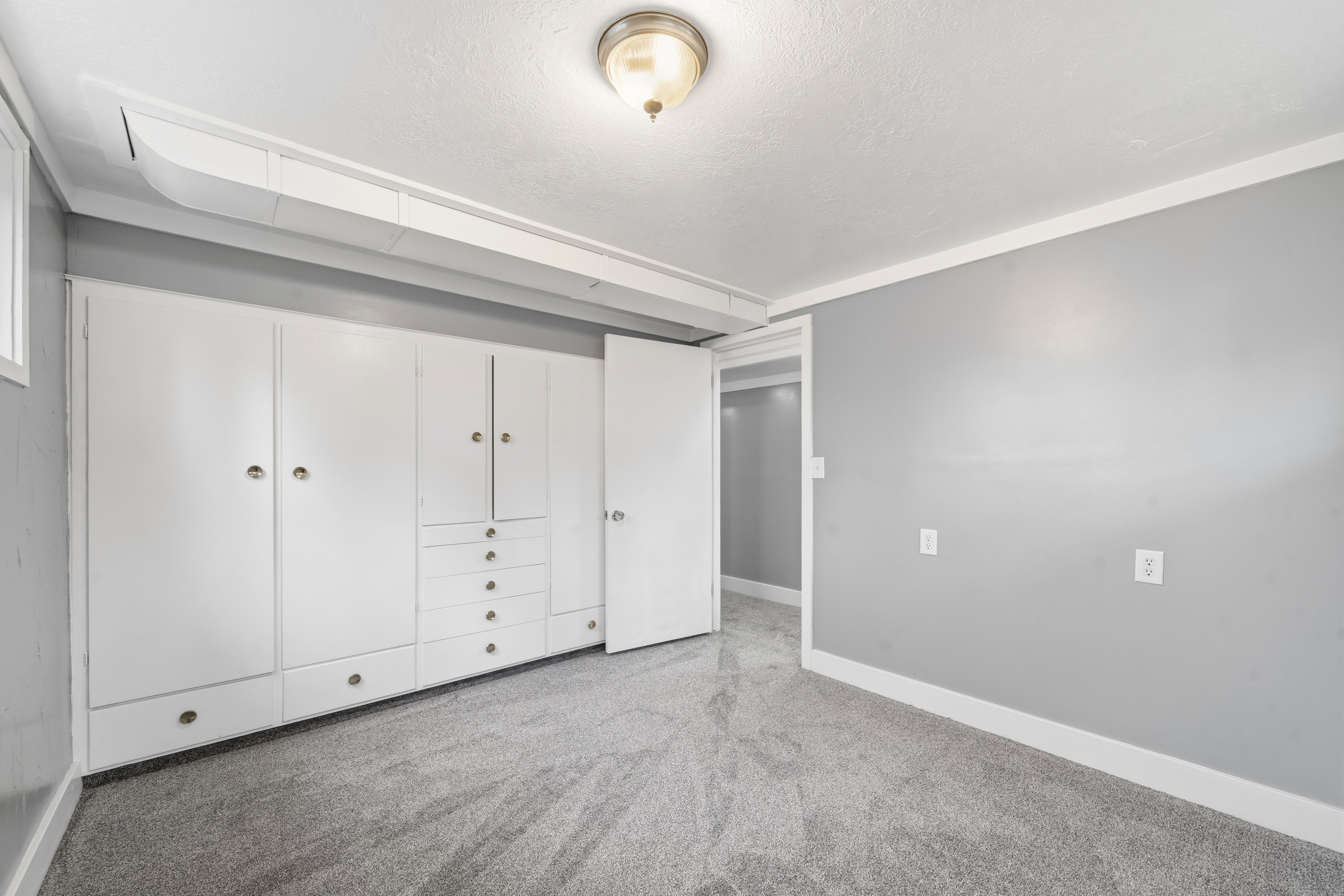 Unfurnished bedroom with light carpet and a textured ceiling