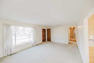 Unfurnished living room with light carpet