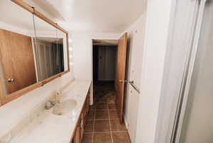 Bathroom featuring vanity and dark tile patterned flooring