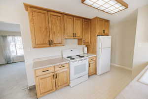 Kitchen with white appliances, light floors, and light countertops