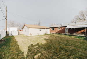 Back of house with a storage unit, a patio area, and brick siding