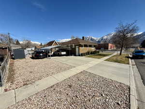 View of yard with a mountain view, concrete driveway, and a shed
