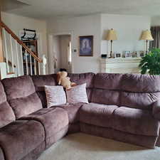 Carpeted living area with stairway and a textured ceiling