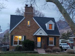 View of front of property with a chimney, brick siding, and a mountain view