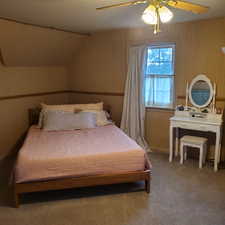Carpeted bedroom with wallpapered walls and a ceiling fan