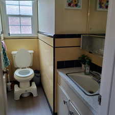 Half bath with vanity, dark wood finished floors, and tile walls
