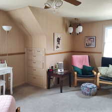 Sitting room featuring wallpapered walls, ceiling fan, and light carpet