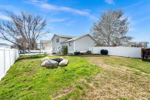 Fenced backyard with a gate and a trampoline