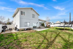 Rear view of property with a patio area, a trampoline, a gate, and a fenced backyard
