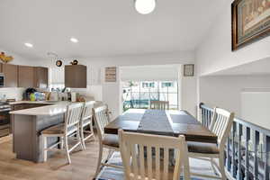 Dining area with light wood-type flooring and recessed lighting