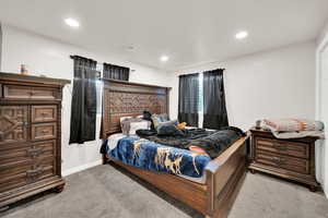 Bedroom with light colored carpet and recessed lighting