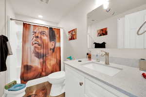 Bathroom featuring vanity, shower / tub combo with curtain, and wood finished floors