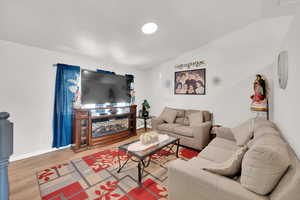 Living area featuring light wood-style flooring and vaulted ceiling