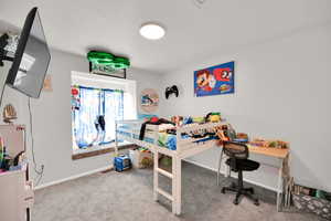 Bedroom with light colored carpet and baseboards
