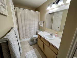 Full bathroom featuring vanity, shower / bath combo, and light tile patterned flooring