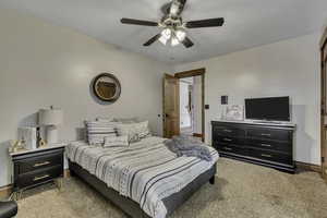 Bedroom with light colored carpet and a ceiling fan
