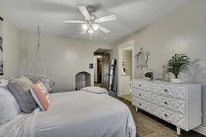 Bedroom featuring ceiling fan, light colored carpet, and ensuite bathroom