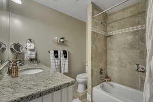 Bathroom with vanity, shower / tub combo, and light tile patterned floors