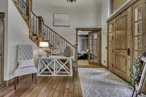 Foyer with light wood-style floors and a high ceiling