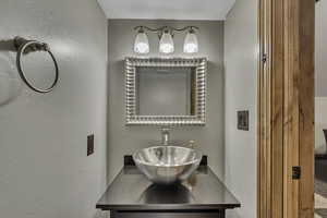 Bathroom with vanity and a textured wall