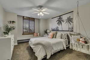 Carpeted bedroom featuring ceiling fan and baseboards