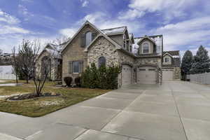 Craftsman-style house with concrete driveway, a high end roof, stone siding, and a garage