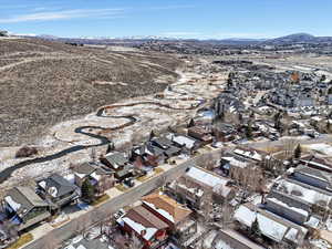 Aerial overview of property's location with a mountain backdrop and nearby suburban area