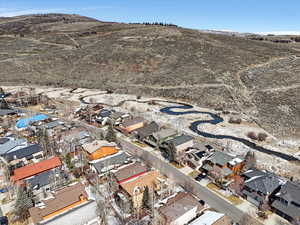 Aerial view of property and surrounding area with nearby suburban area and a mountain backdrop
