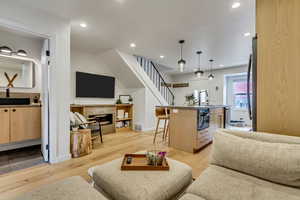 Living room featuring light wood-style flooring, a high end fireplace, and recessed lighting