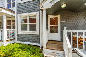 Doorway to property featuring a tile roof and a wooden deck