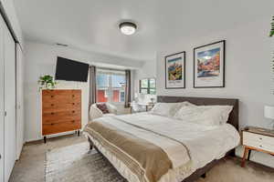 Bedroom with light carpet and a closet