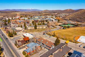Aerial view of property and surrounding area with mountains and nearby suburban area
