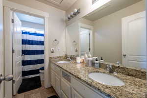 Bathroom featuring double vanity and curtained shower