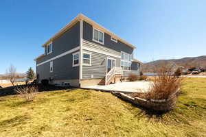 Rear view of house featuring a lawn and a mountain view