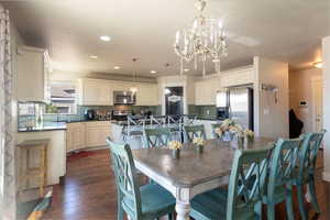 Dining room featuring dark wood finished floors and a chandelier