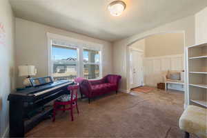 Living area featuring arched walkways and carpet floors