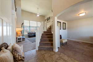Staircase with carpet floors and ceiling fan