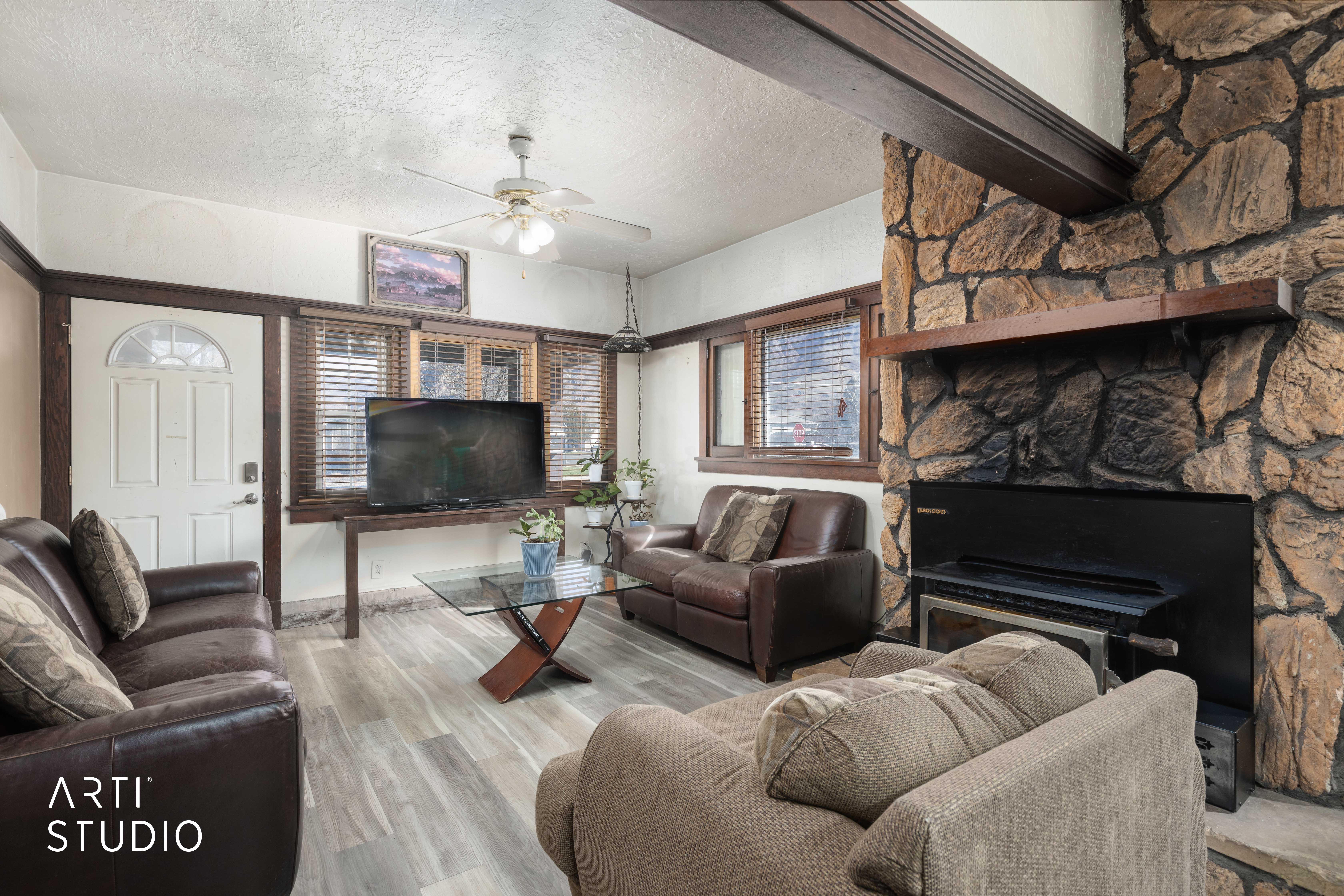 Living area with a textured ceiling, a ceiling fan, and wood finished floors