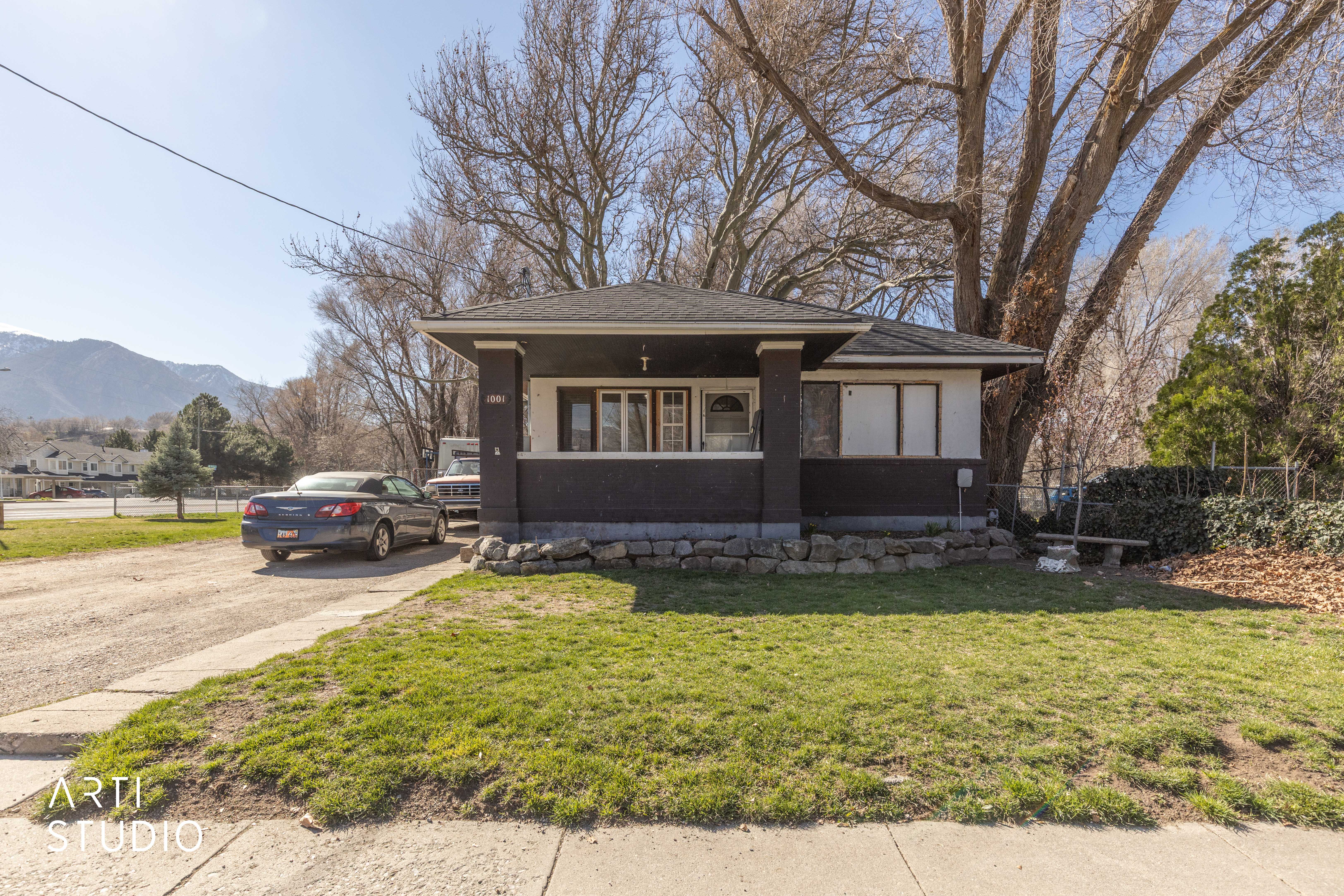 View of front of home with stucco siding, a mountain view, and a porch