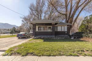 View of front of home with stucco siding, a mountain view, and a porch