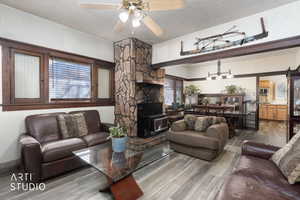 Living room featuring ceiling fan, a textured ceiling, and wood finished floors