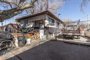 View of side of home with a gate and stucco siding