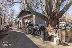 View of property exterior featuring concrete block siding, an outdoor structure, and a detached garage