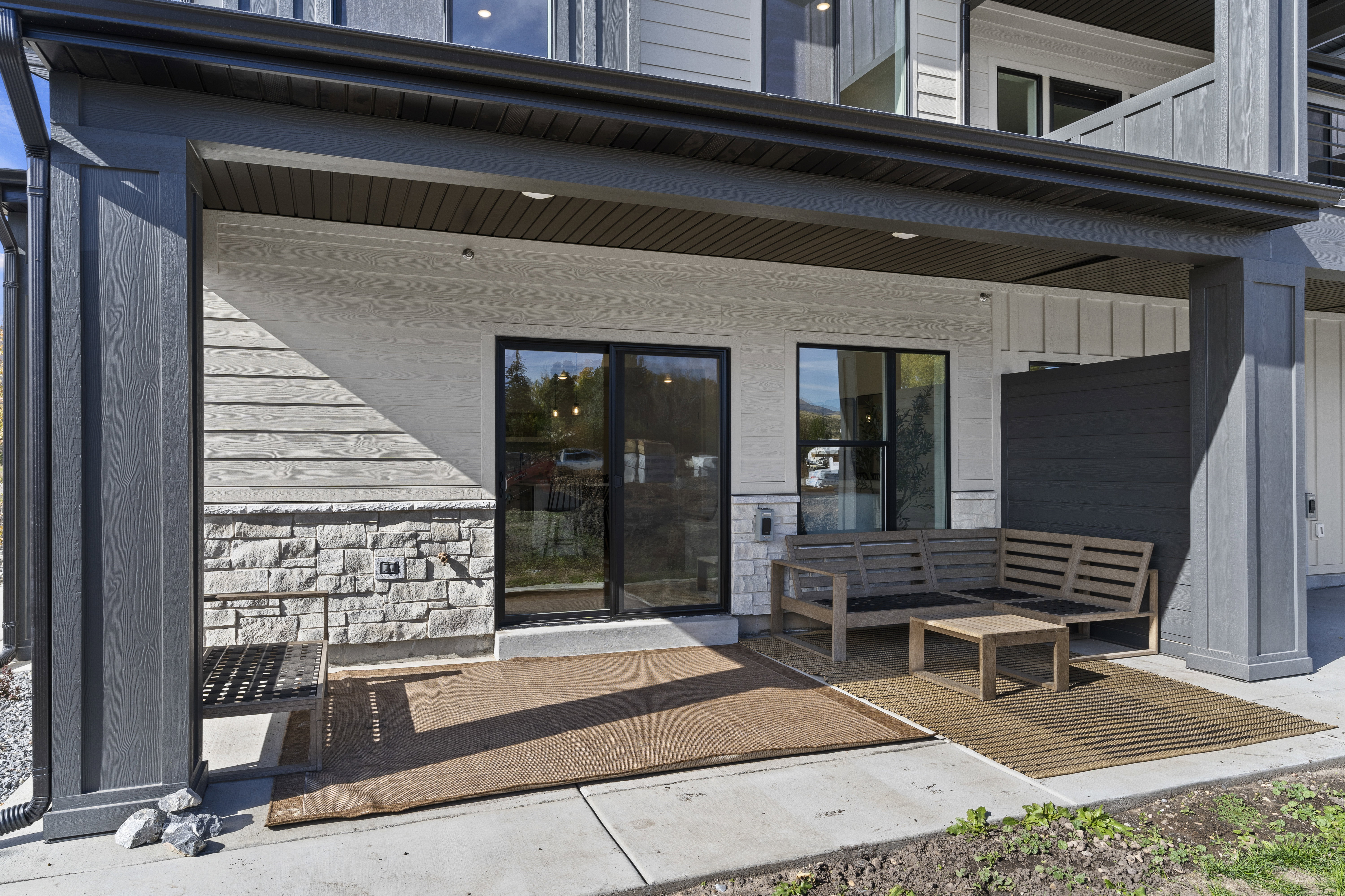 Doorway to property with stone siding and an outdoor lounge area