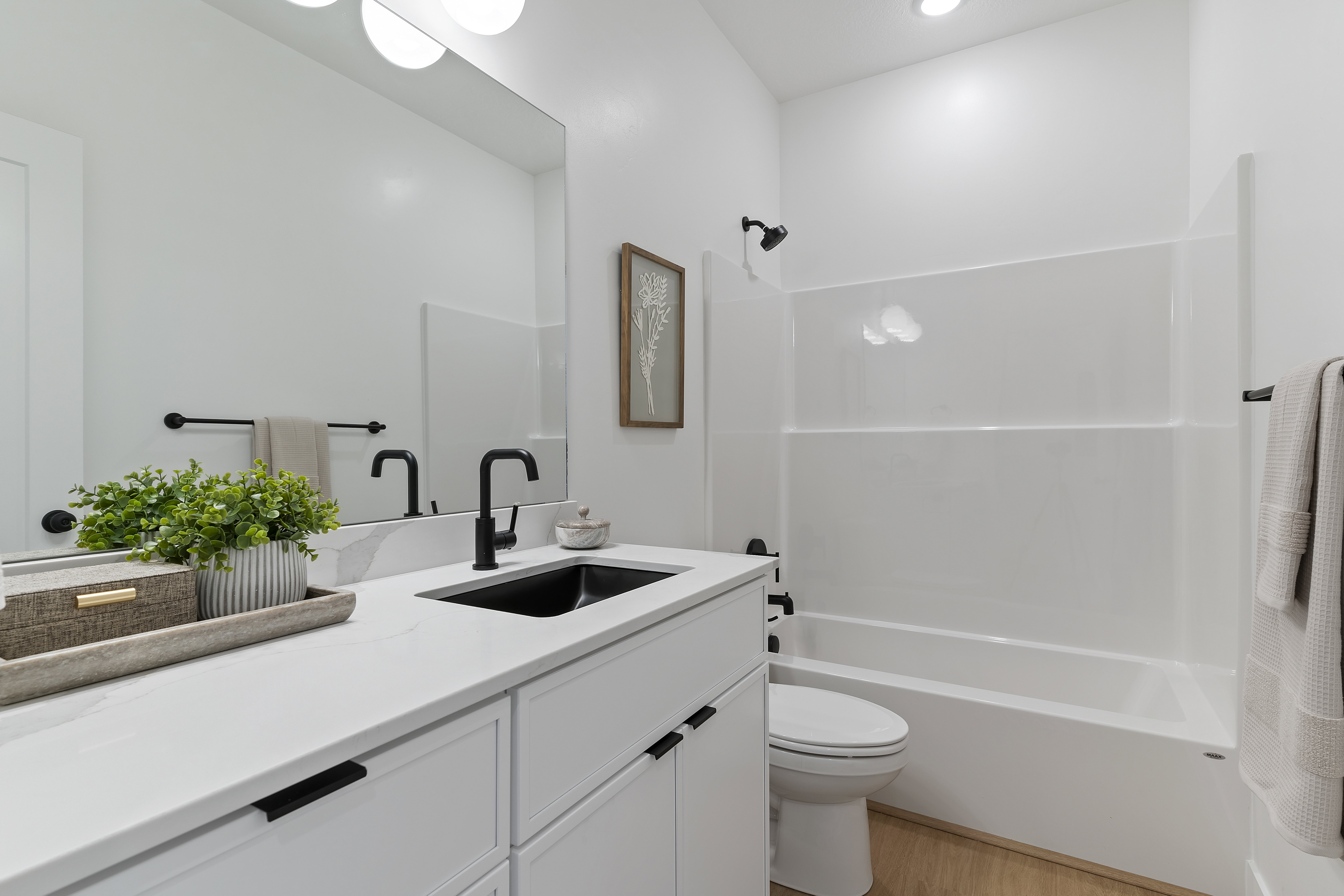 Bathroom featuring vanity, shower / washtub combination, and light wood finished floors