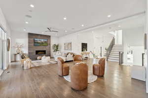 Living room with a fireplace, ceiling fan, hardwood / wood-style floors, recessed lighting, and healthy amount of natural light