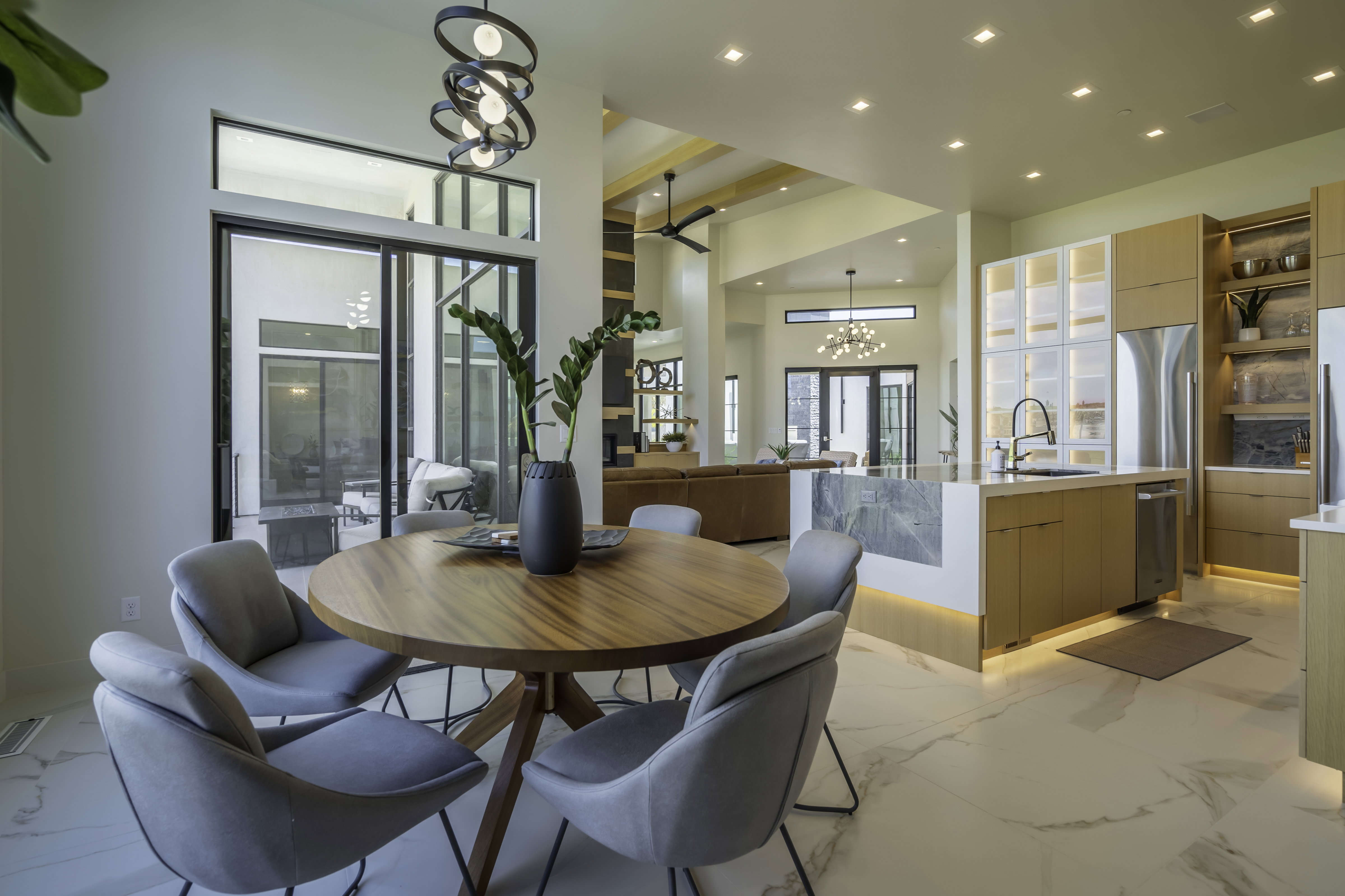 Dining room with suspended lighting and light marble finish floors