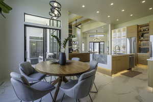 Dining room with suspended lighting and light marble finish floors