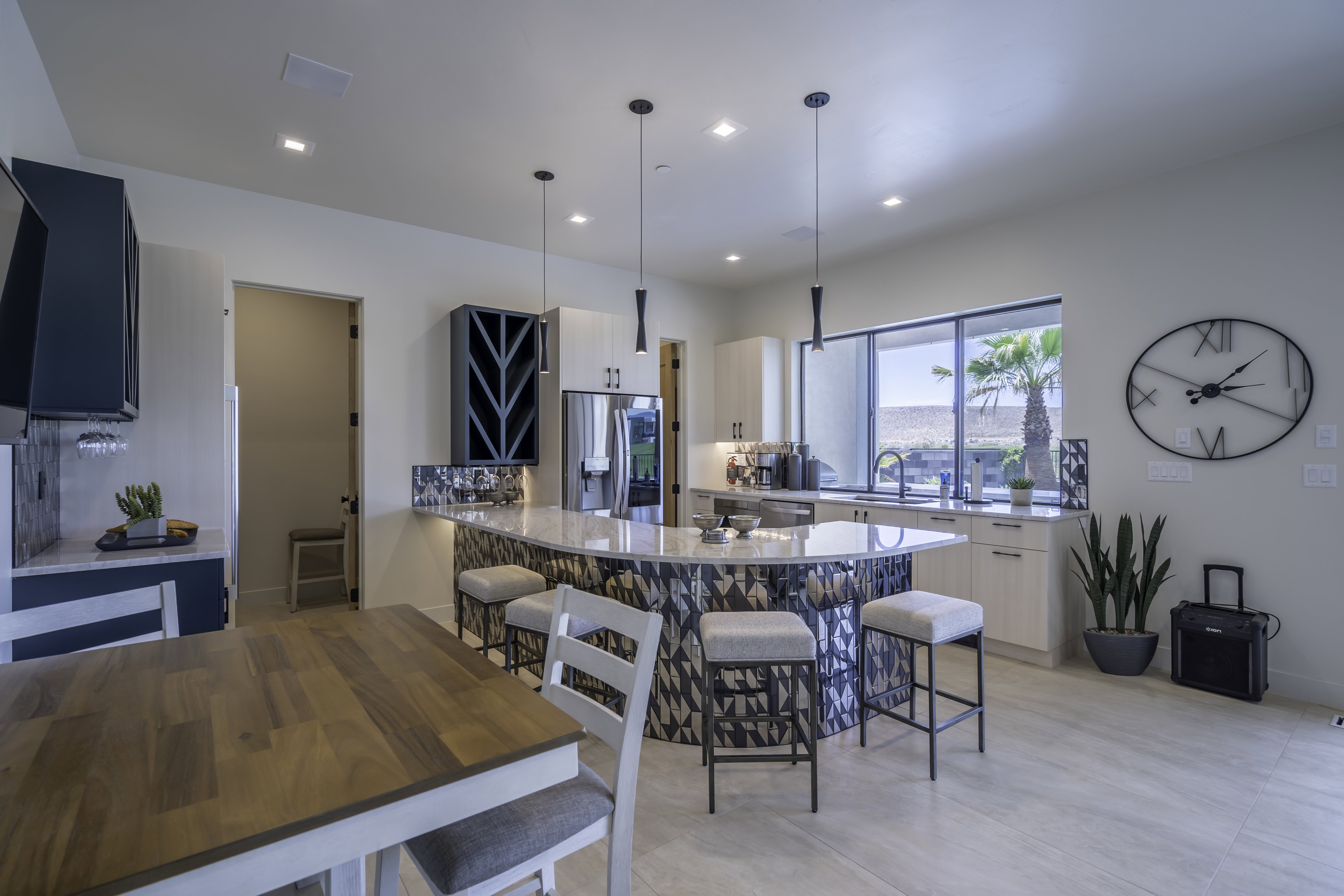 Kitchen with a kitchen bar, light stone countertops, a peninsula, and decorative light fixtures