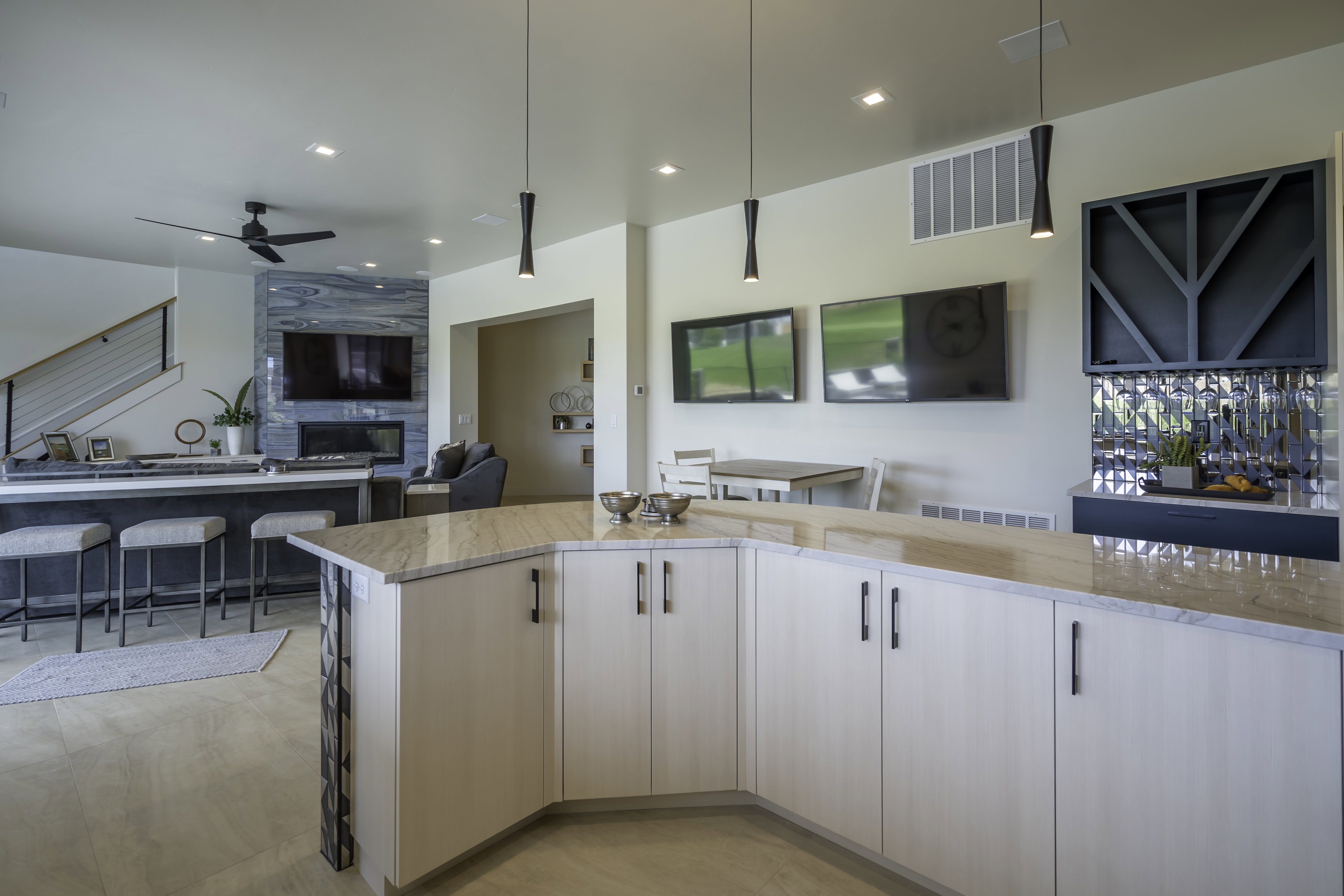 Kitchen with open floor plan, light stone countertops, ceiling fan, a fireplace, and hanging light fixtures